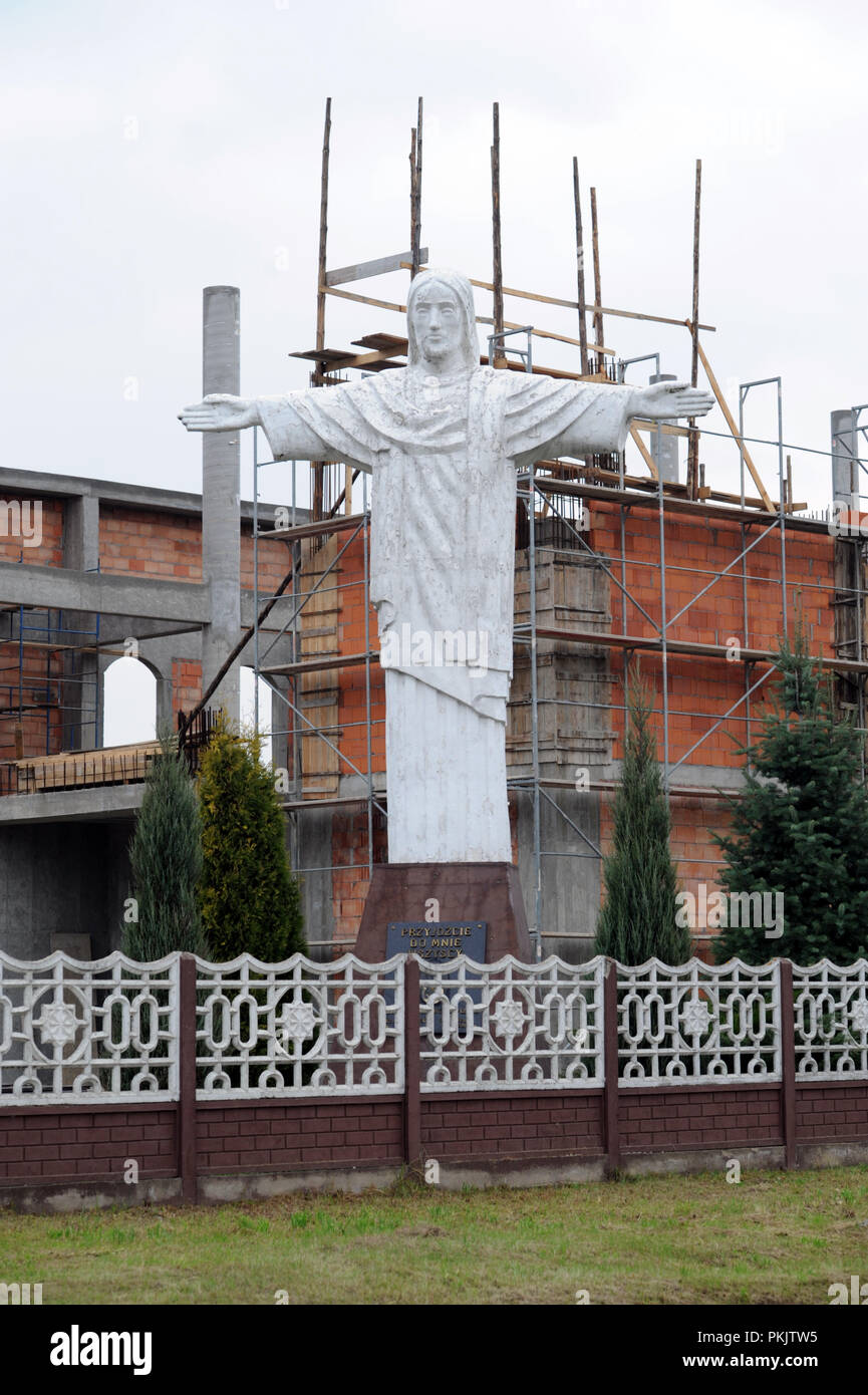 Large 10m statue of Jesus outside a Catholic church under construction in  Poland Stock Photo
