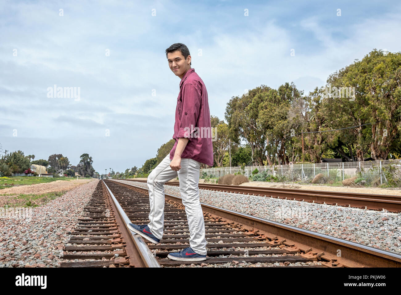 Young male standing on railway tracks, Carlsbad, California Stock Photo
