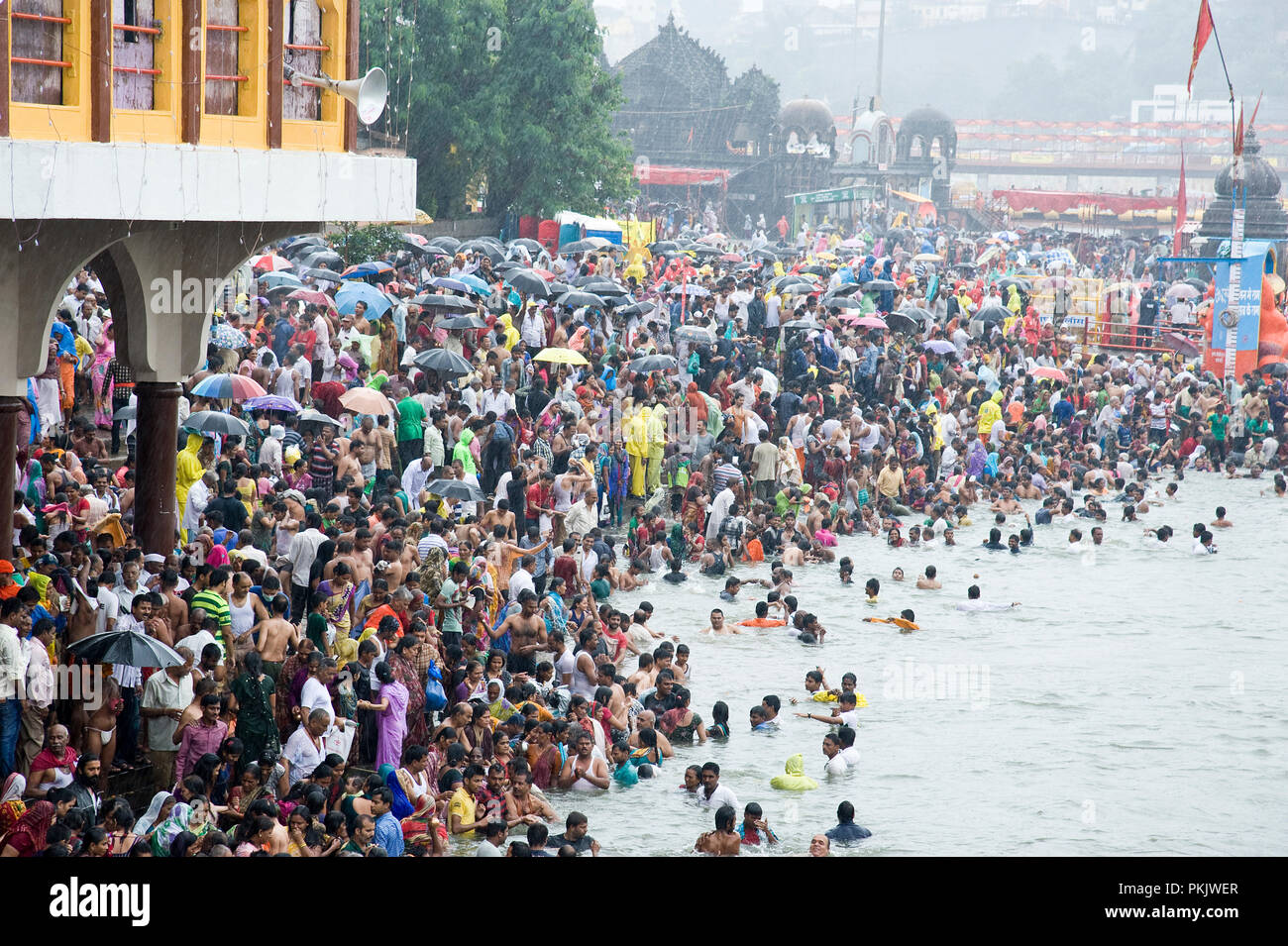 Crowd of Hindu devotees for taking Holy Dip in kumbha mela at nashik Panchavati  in godavari river maharashtra India Stock Photo