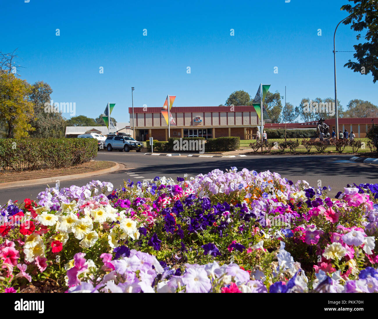 Main street of Australian outback town of Cunnamulla with colourful bed of flowers, despite the drought, and blue sky Stock Photo
