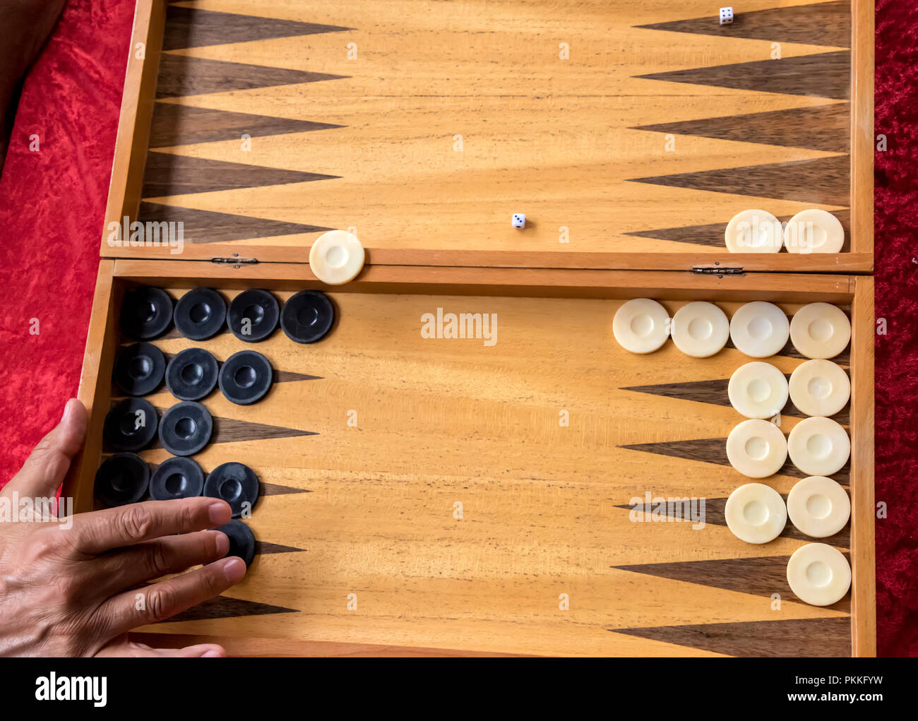 a man moves a checker in a backgammon game Stock Photo