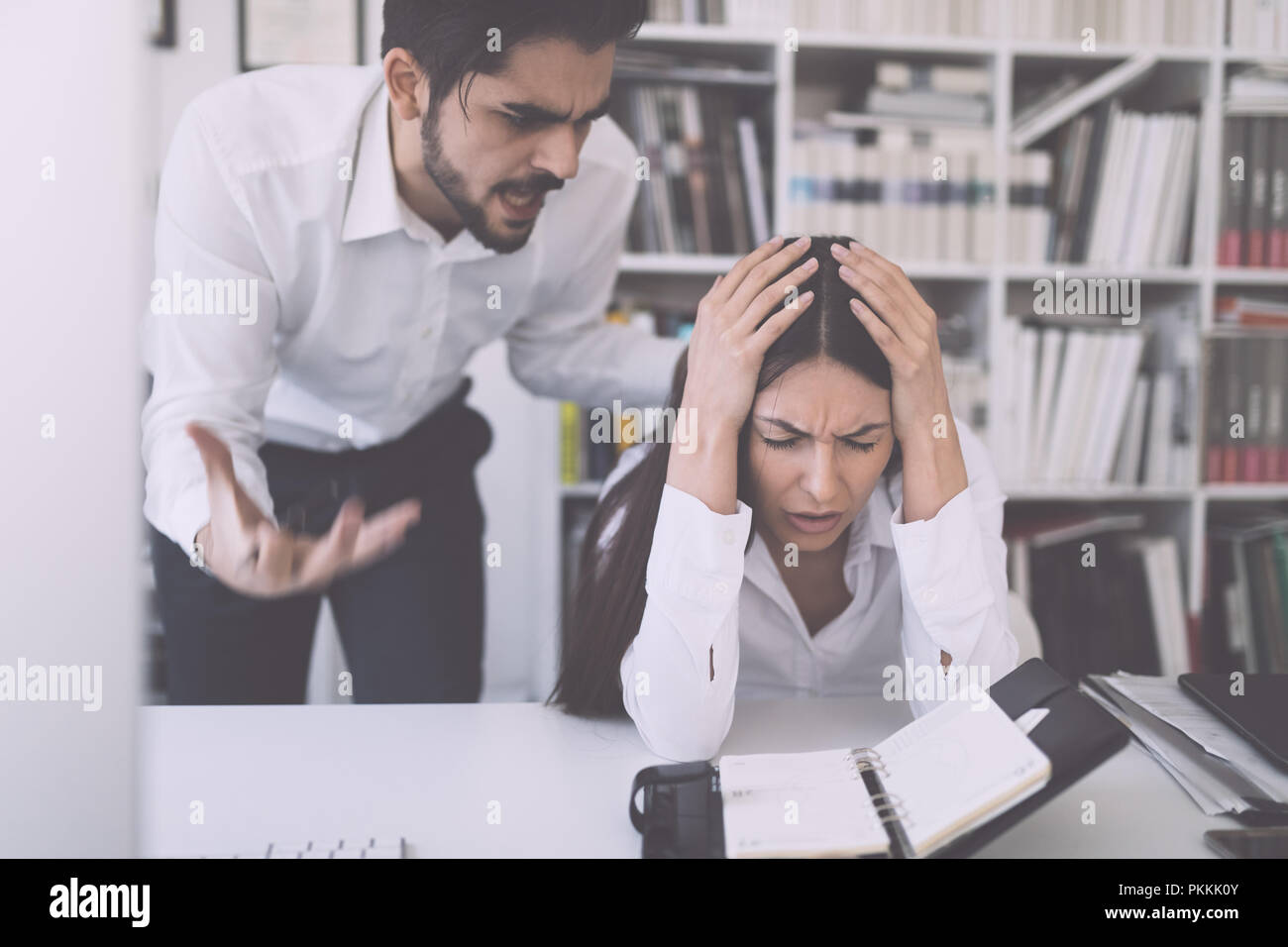Businessman yelling at female colleague in office Stock Photo