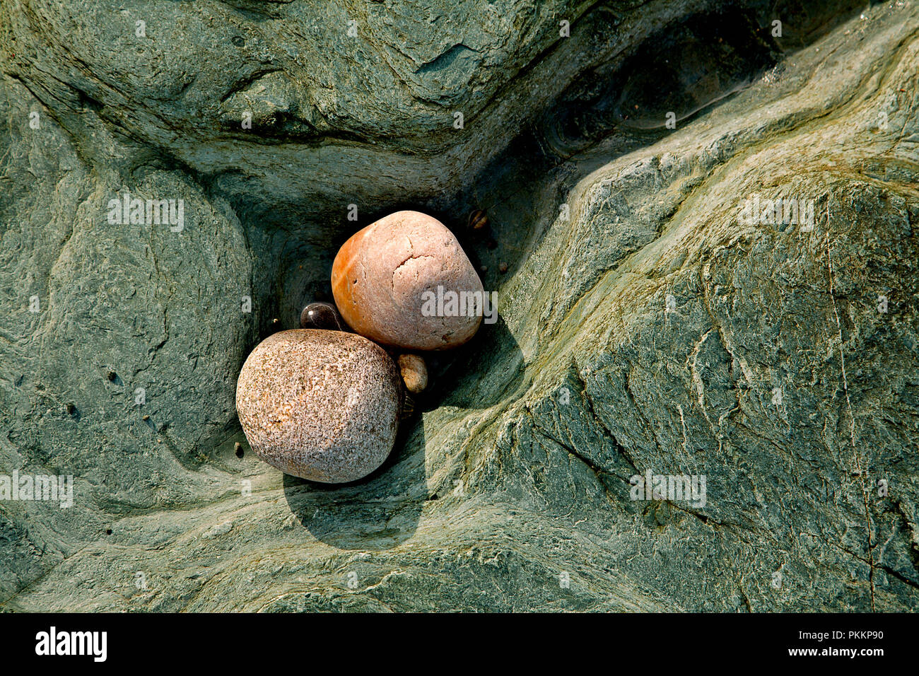 Colourful eroded rock and stones on the Welsh coast at Cemlyn, Anglesey Stock Photo