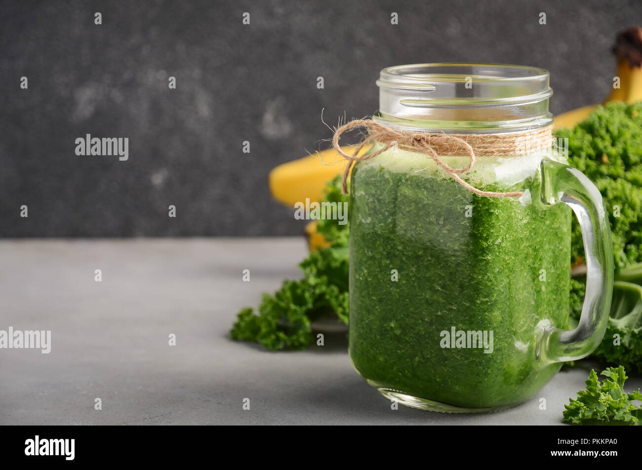 Fresh green smoothie with kale and banana in a jar, selective focus. Stock Photo