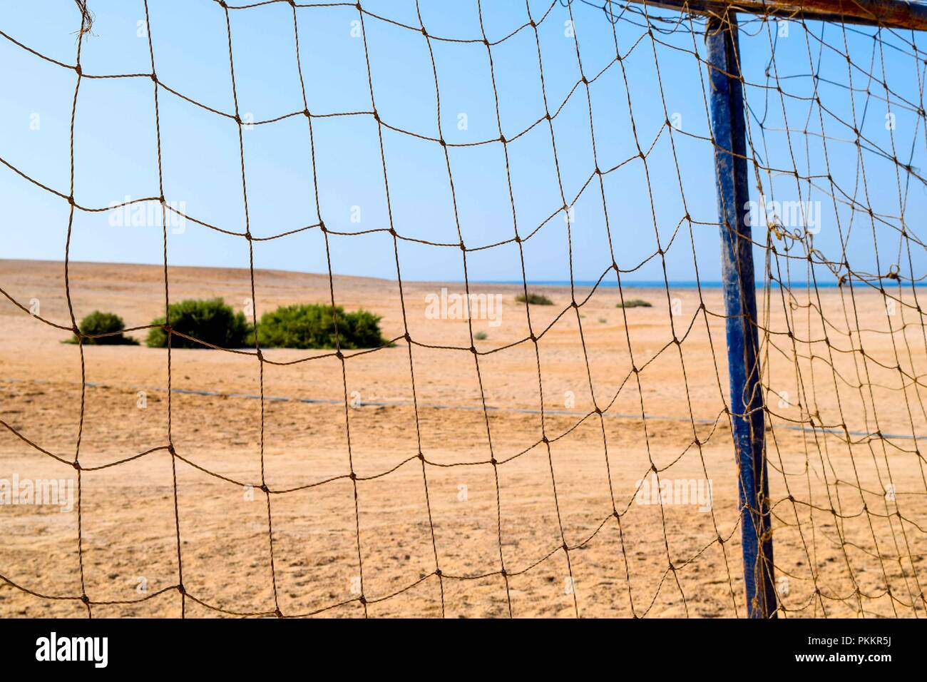 View trough soccer net goal on the beach, soccer goal in sand, egypt