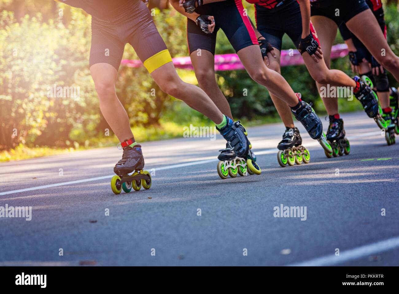 Inline roller skaters racing in the park on asphalt road Stock Photo