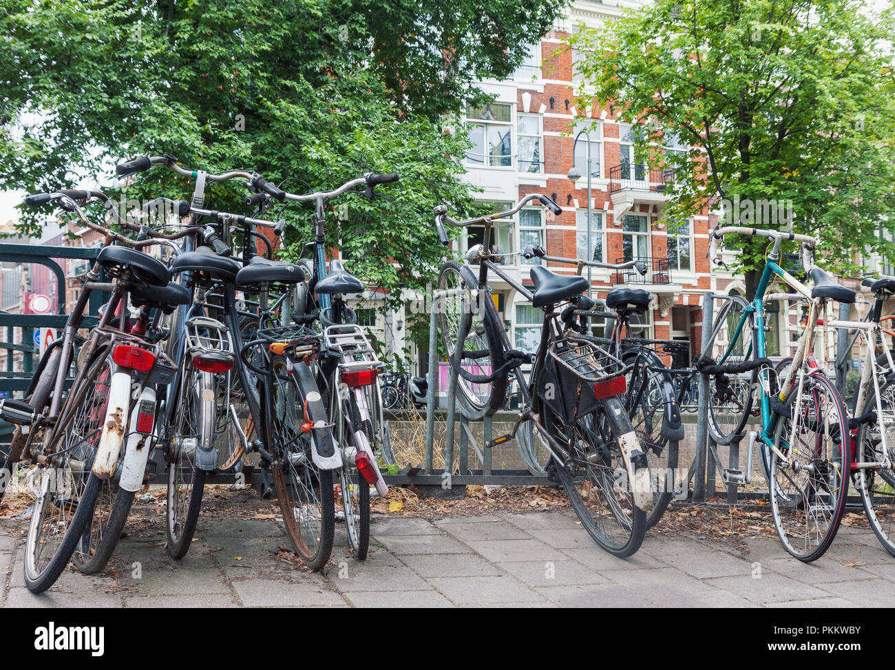 Group of old weathered vintage bicycles parked on the street in Amsterdam, Netherlands Stock Photo