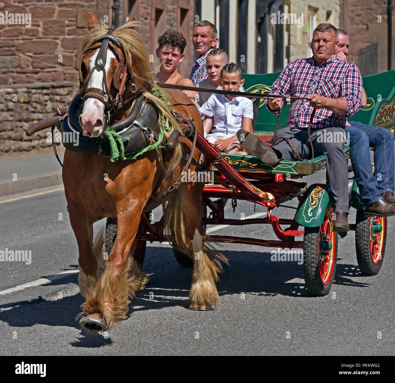 Six Gypsy Travellers riding on cart. Appleby Horse Fair 2018. The Sands, Appleby-in-Westmorland, Cumbria, England, United Kingdom, Europe. Stock Photo