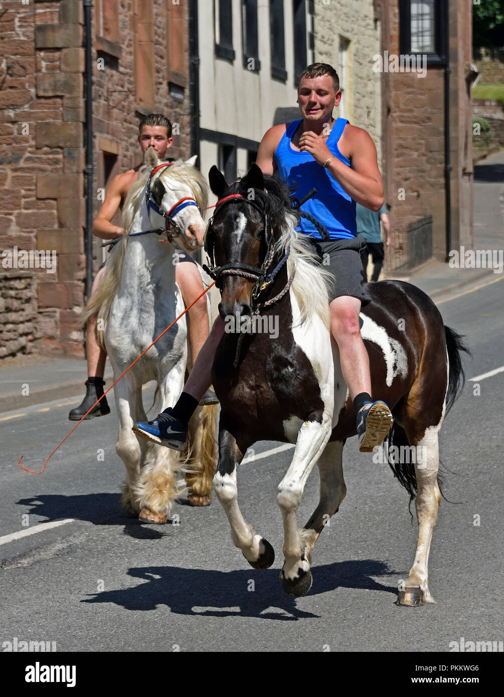 Two Gypsy Travellers riding horses at Appleby Horse Fair 2018. The Sands, Appleby-in-Westmorland, Cumbria, England, United Kingdom, Europe. Stock Photo