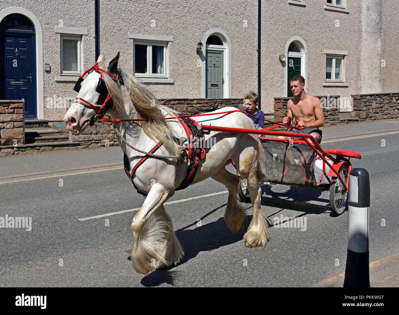 Two Gypsy Travellers riding on cart. Appleby Horse Fair 2018. The Sands, Appleby-in-Westmorland, Cumbria, England, United Kingdom, Europe.cart Stock Photo