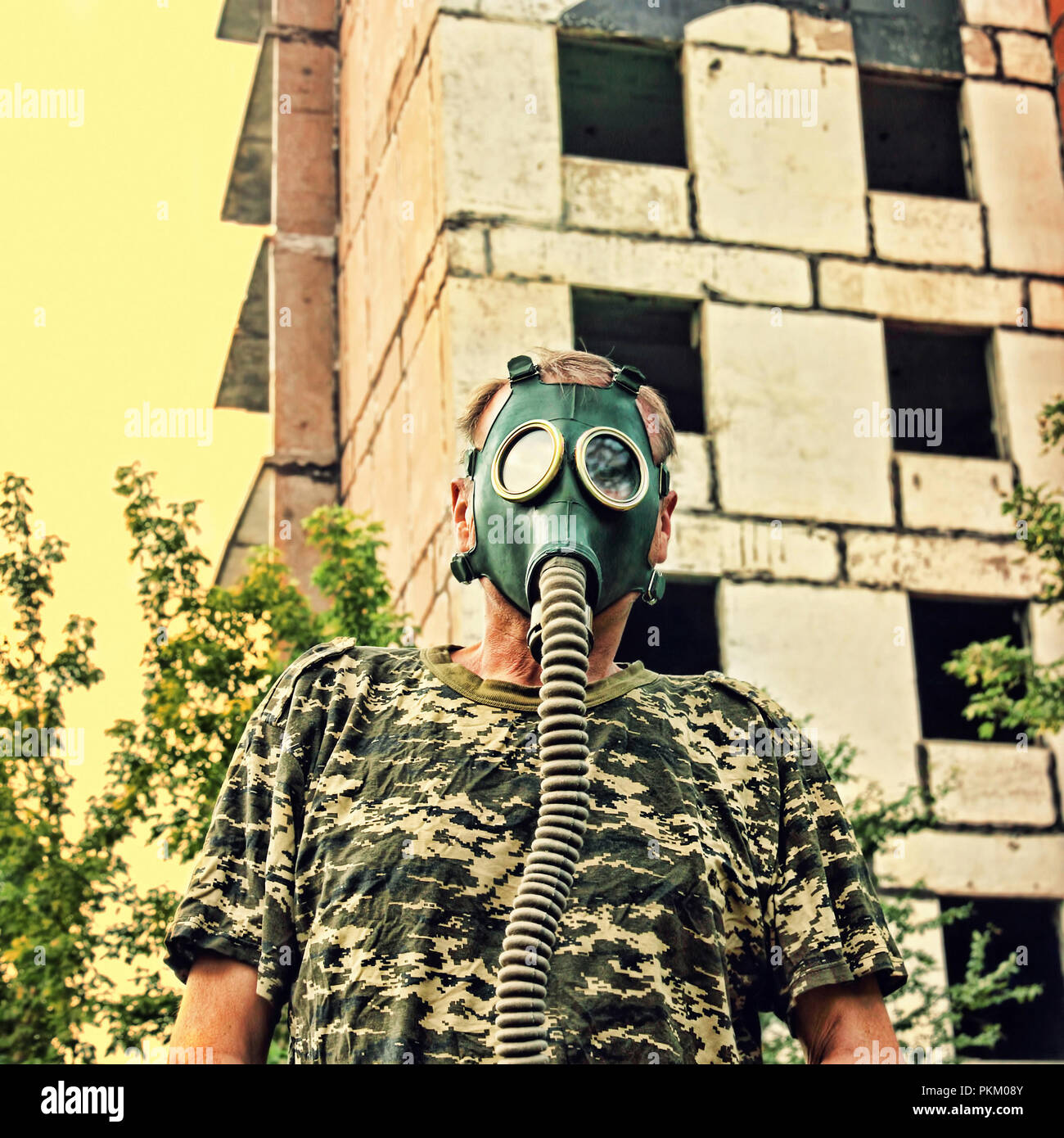 Men in gas mask against the ruined building. Apocalyptic concept