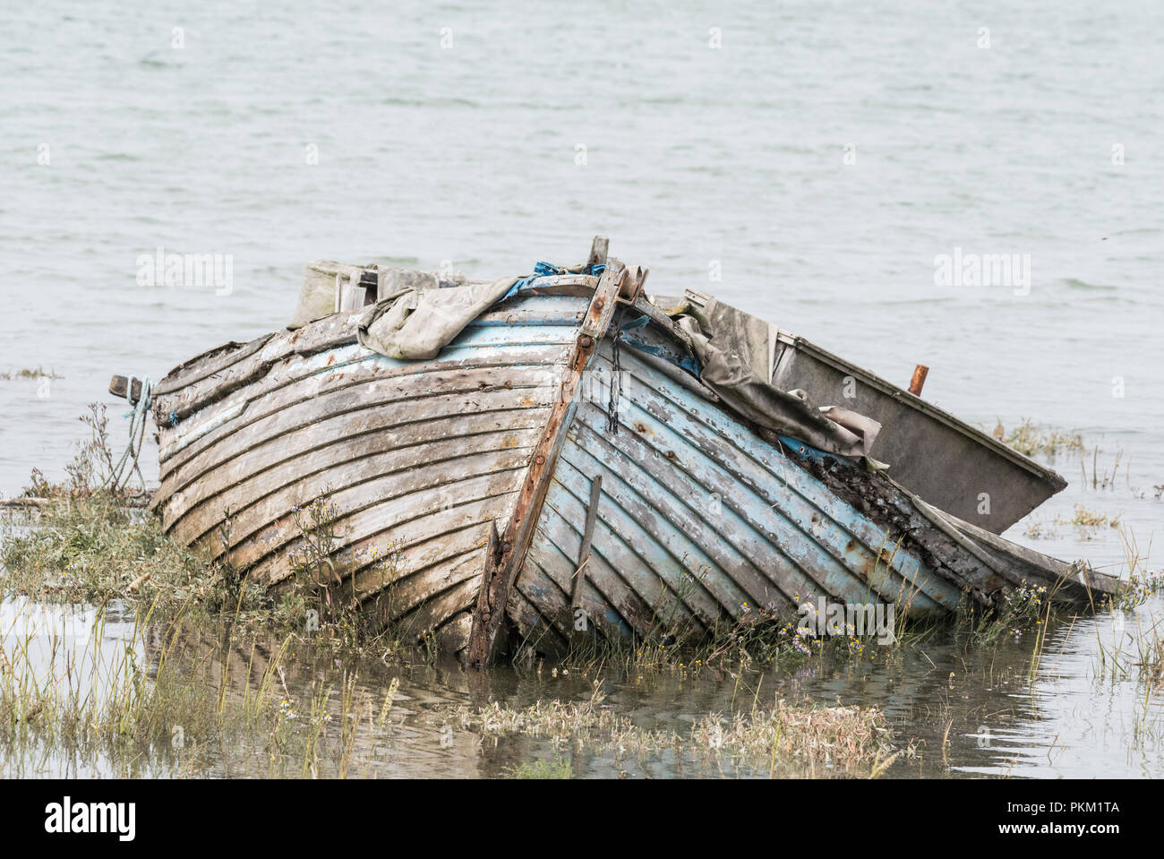 An abandoned wooden rowing boat on the River Stour Stock Photo