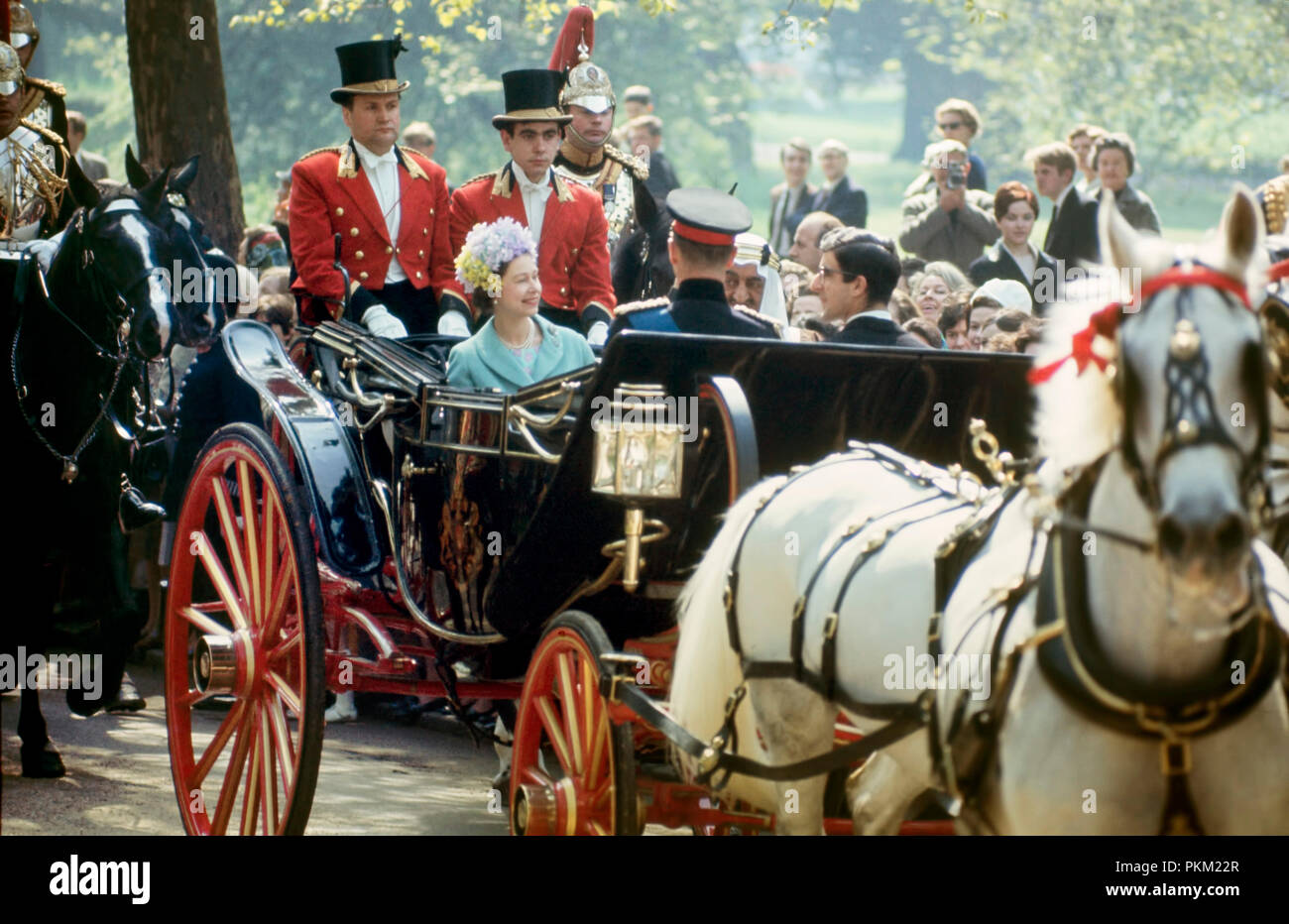 A State Visit in May; 1967; Her Majesty Queen Elizabeth ll, accompanied by her husband, the Duke of Edinbugh (Prince Phillip), rides in an open carriage with King Faisal of Saudi Arabia on the Mall towards Buckingham Palace. They are escorted by guards in ceremonial dress. Stock Photo