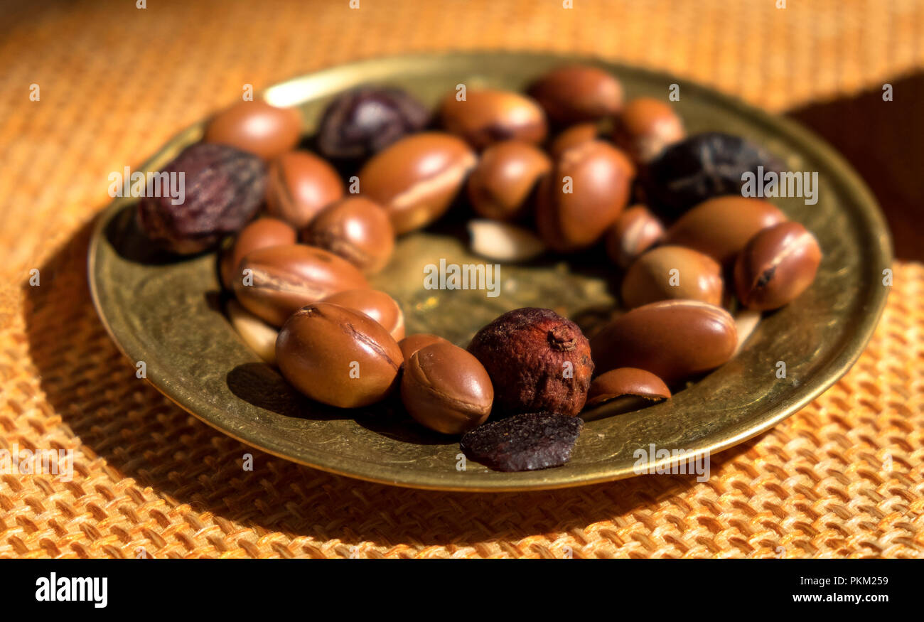 Argan nuts seeds on a plate - Argan is useful as antioxidant for healing redness inflammations skin stretch marks Stock Photo