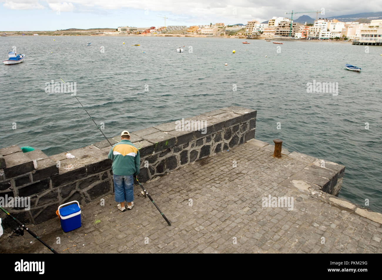 Fisherman behind the harbour wall at El Medano, Tenerife, Canary Islands, Spain. 2006 Stock Photo