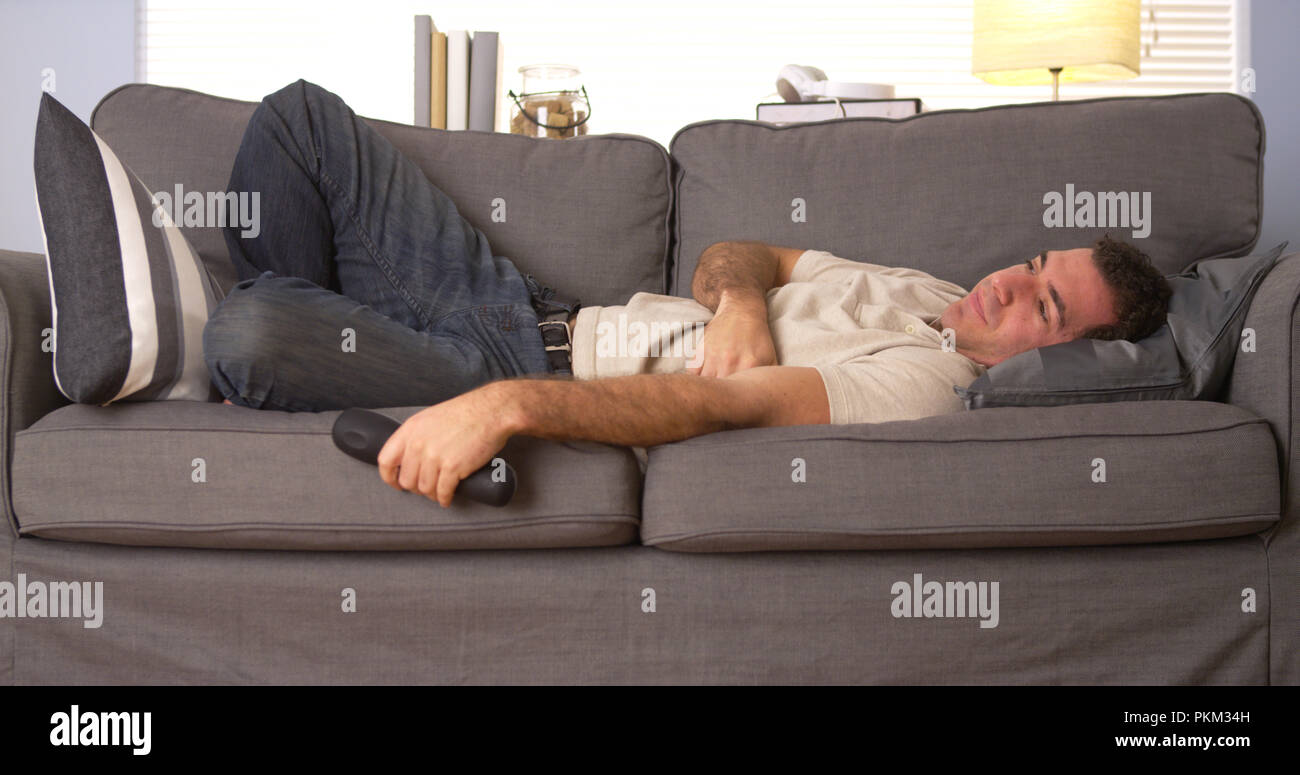 Guy trying to sleep on couch Stock Photo Alamy