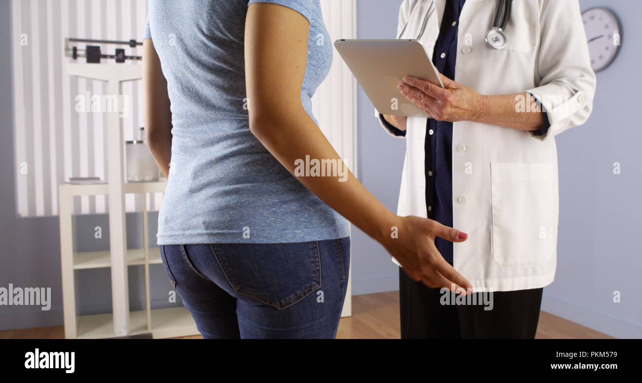 Senior doctor talking with overweight Mexican patient Stock Photo