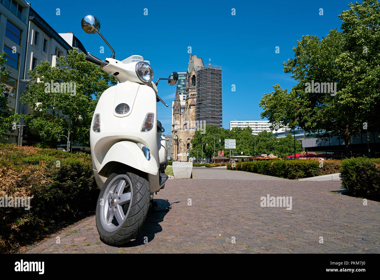 Parked scooter in downtown Berlin. In the background is the Breitscheidplatz with the Memorial Church. Stock Photo