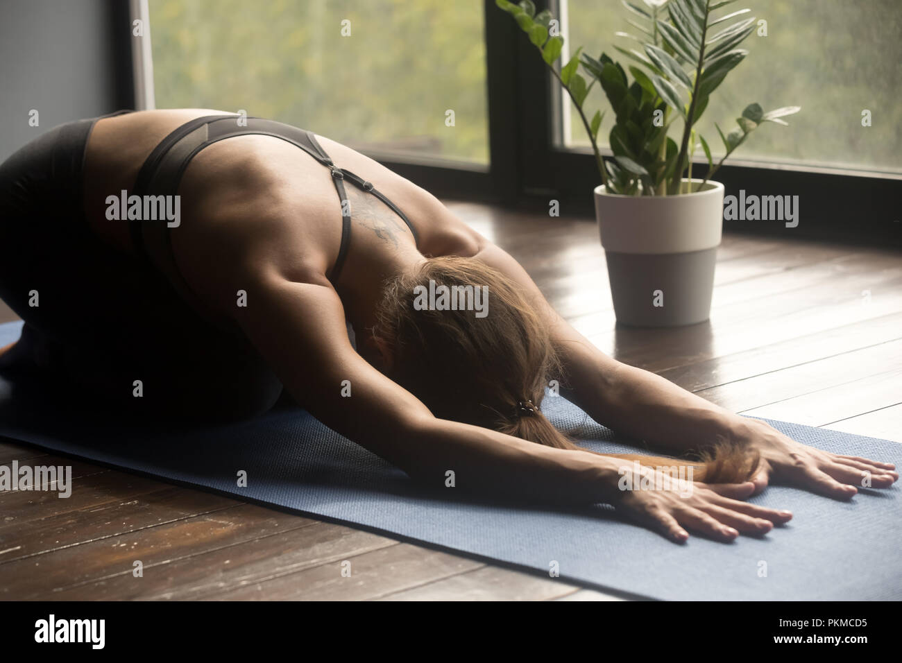 Young yogi woman doing Balasana pose, close up Stock Photo