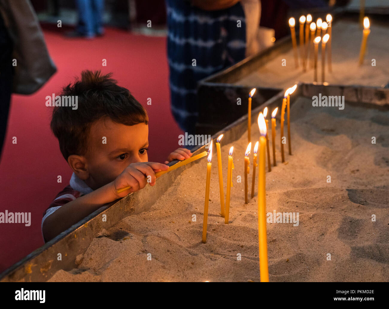 Little boy lighting the candles in the church Stock Photo Alamy