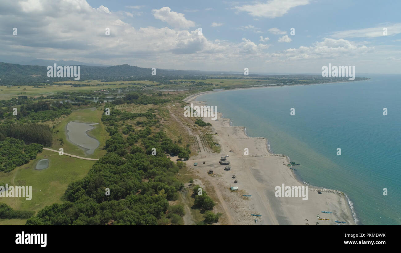 Aerial view of coastline with sandy beach, azure water on the island Luzon, Philippines. Seascape, ocean and beautiful beach. Agoo Damortis National Seashore Park. Stock Photo