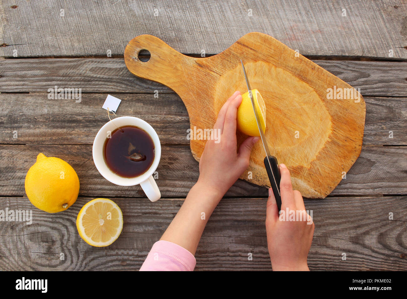 Woman prepares tea with lemon. Top view. Stock Photo