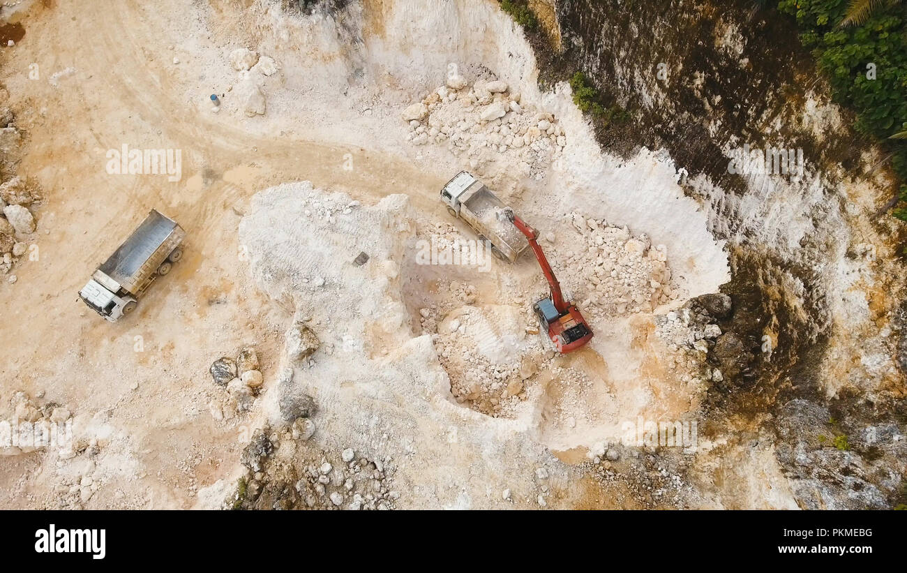 Excavator loads the truck in a limestone quarry. Aerial view wheel