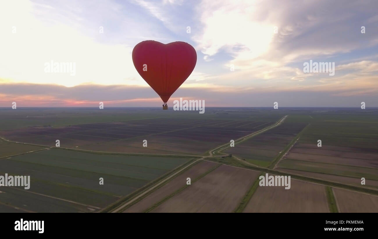 Hot air balloon shape of a heart in the blue sky. Aerostat, Airship ...