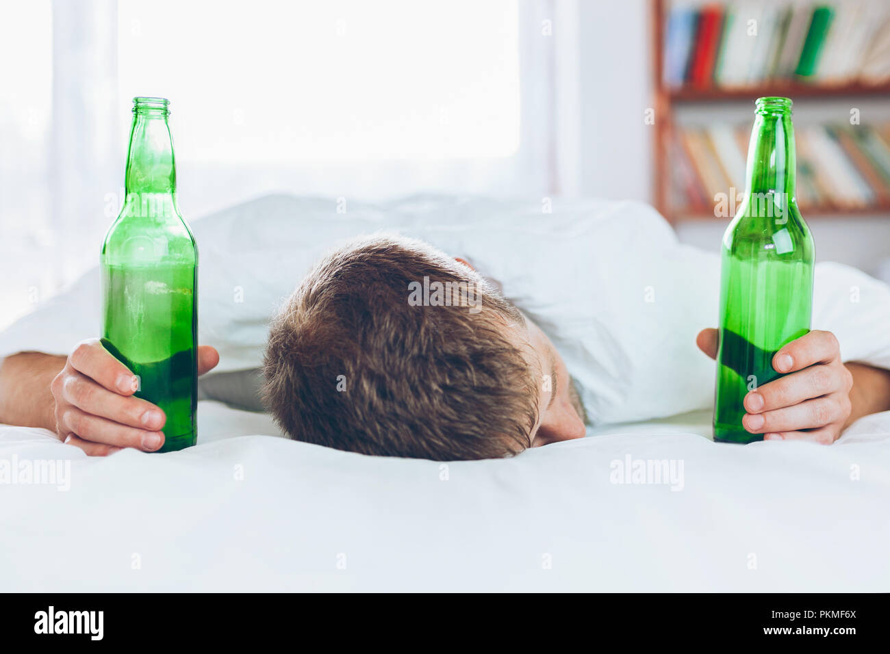 Young handsome man in bed the morning after night out drinking Stock Photo