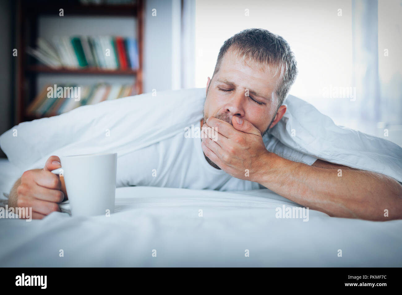 Man trying to wake up in the morning after night out Stock Photo