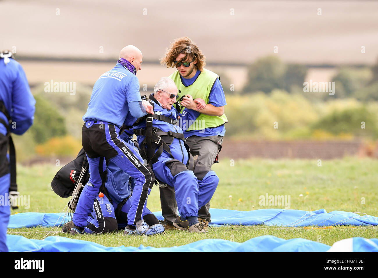 D-Day veteran Harry Read, 94, is helped up after a safe landing at Old Sarum Airfield, Salisbury, Wiltshire, where he is taking part in his first high level skydive since he parachuted into Normandy on 6 June 1944. Stock Photo