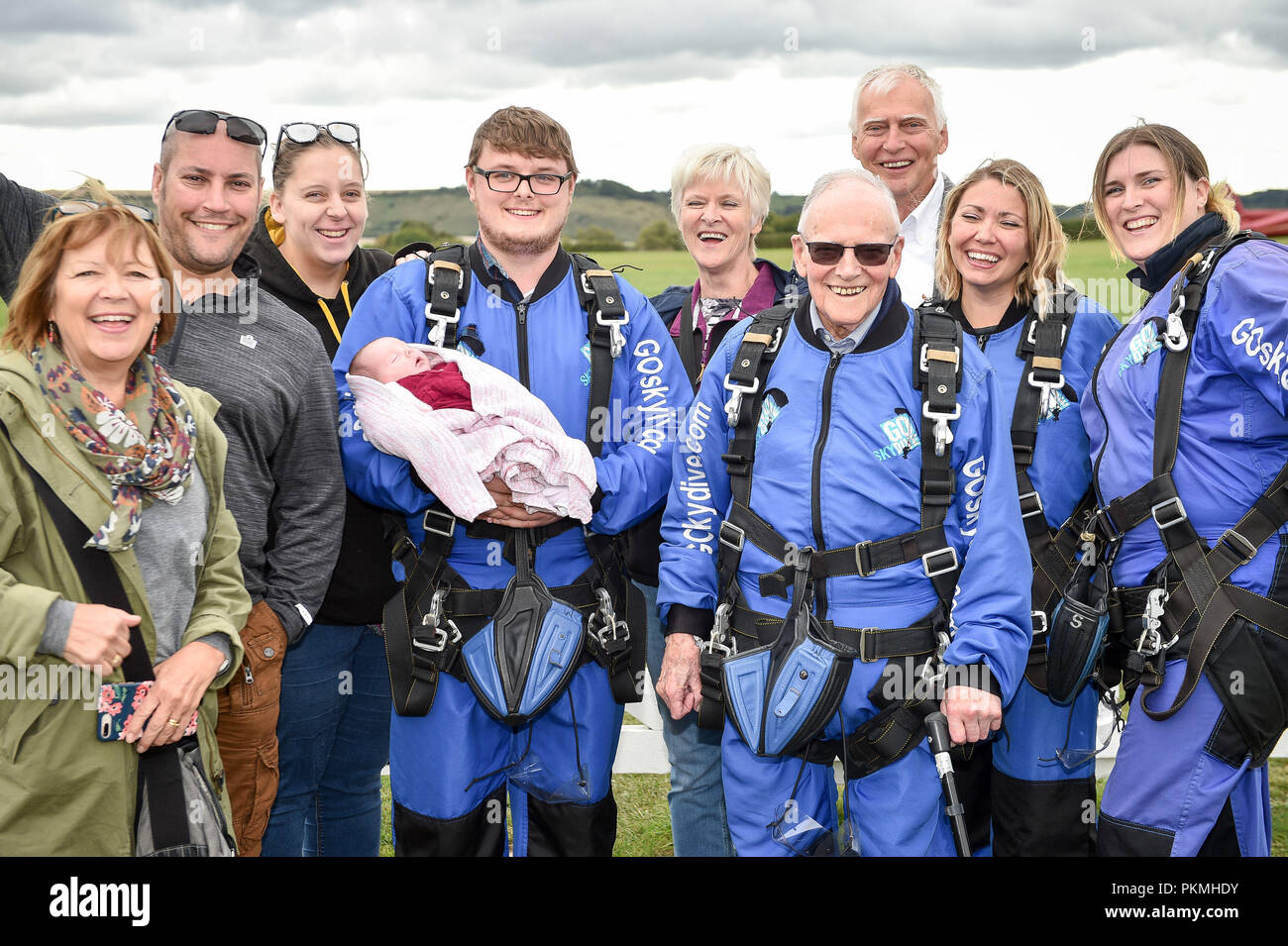 D-Day veteran Harry Read, 94, in his jump-suit with his family (left to right) daughter-in-law Anne Read, 63, grandson-in-law Paul Sealey, 39, great granddaughter-in-law Aimee Shaw, 23, great great granddaughter Isabella Shaw aged three weeks, great grandson Josh Shaw, 23, daughter Margaret Ord, 63, son John Read, 67, granddaughter Jo Taylor, 38, and granddaughter Lianne Sealey, 36, at Old Sarum Airfield, Salisbury, Wiltshire, where he is taking part in his first high level skydive since he parachuted into Normandy on 6 June 1944. Stock Photo