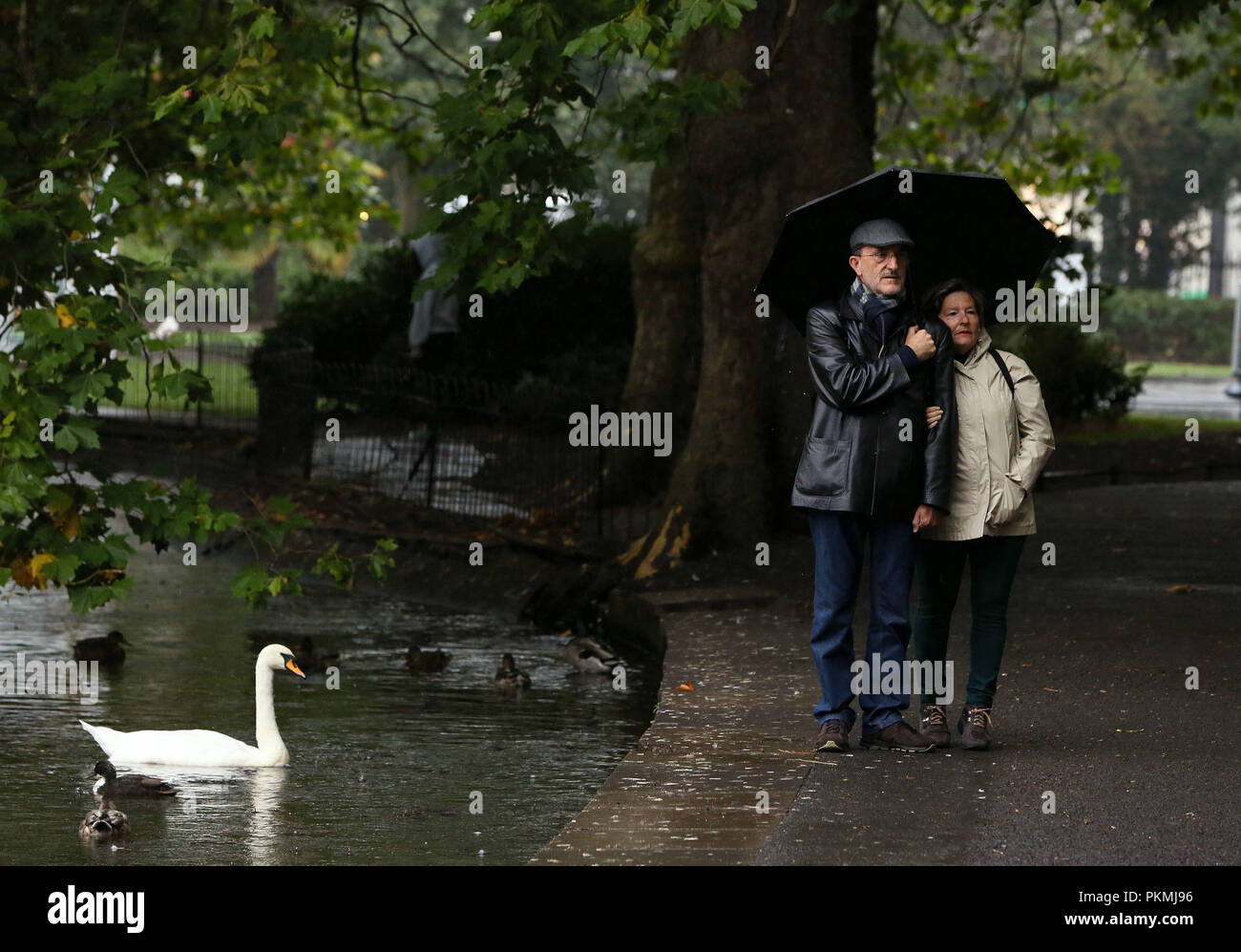 Tourists pose for photographs in St. Stephen's Green in Dublin's city