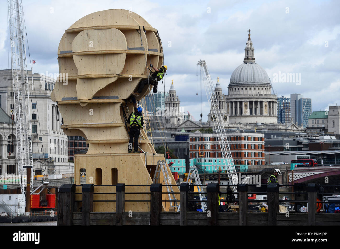 Workmen install the Head Above Water sculpture created by British designer Steuart Padwick in support of Time to Change, the anti-stigma mental health campaign, goes on display on the South Bank in London. Stock Photo