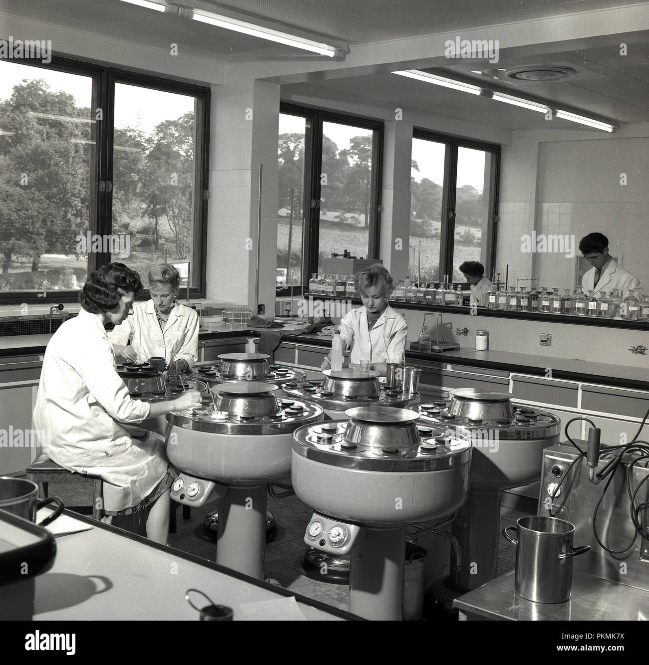 1950s, historical, female researchers in white-coats mixing chemicals to produce dyes for use in textiles, England. Stock Photo