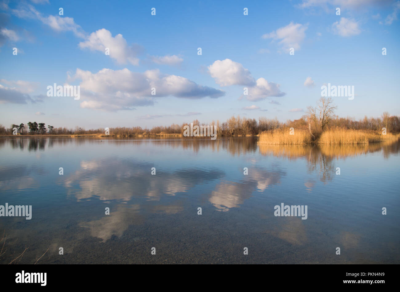Cloudy blue sky reflecting in the lake Stock Photo - Alamy