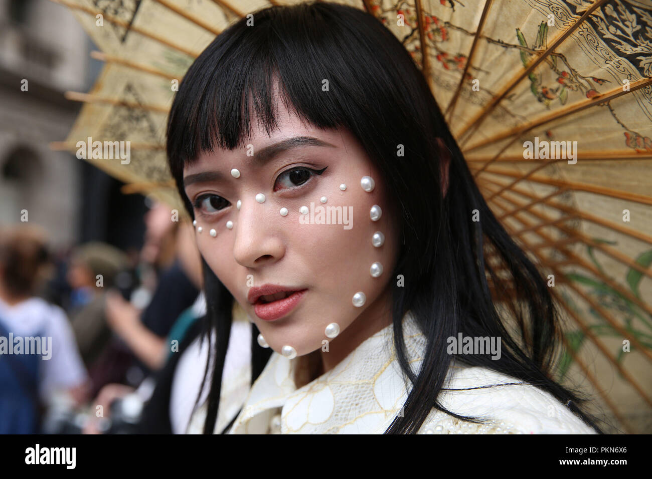 Fashion Blogger Freya Sinyu Siu, from China, wears The Seventh Tail coat, Moyasusu dress, ASOS boots, and vintage bag and umbrella during the London Fashion Week September 2018. PRESS ASSOCIATION. Picture date: Friday September 14, 2018. Photo credit should read: Isabel Infantes/PA Wire Stock Photo