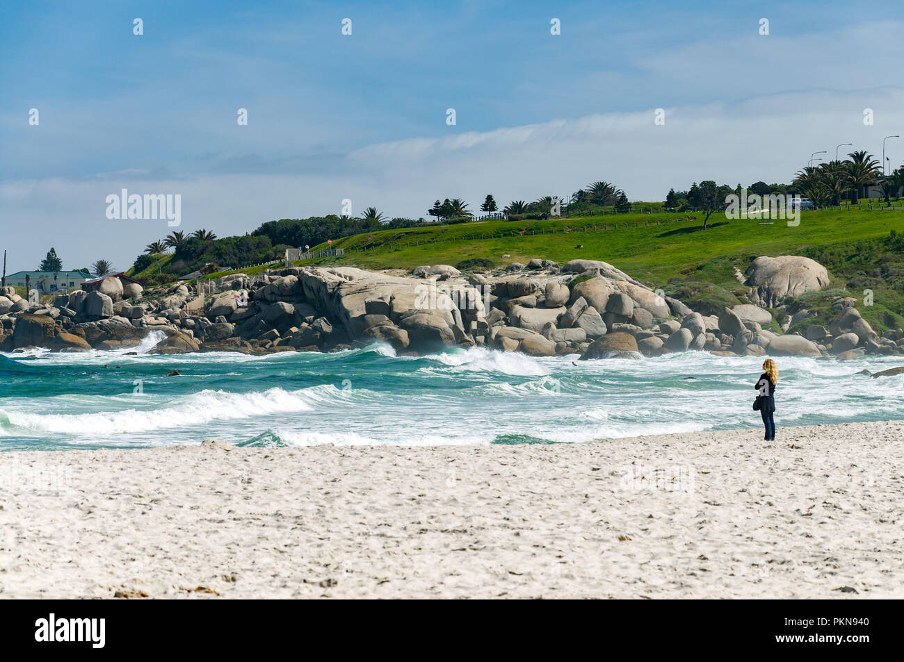 Lone woman on a beach looking out to sea, South Atlantic ocean, Camps Bay, South Africa Stock Photo