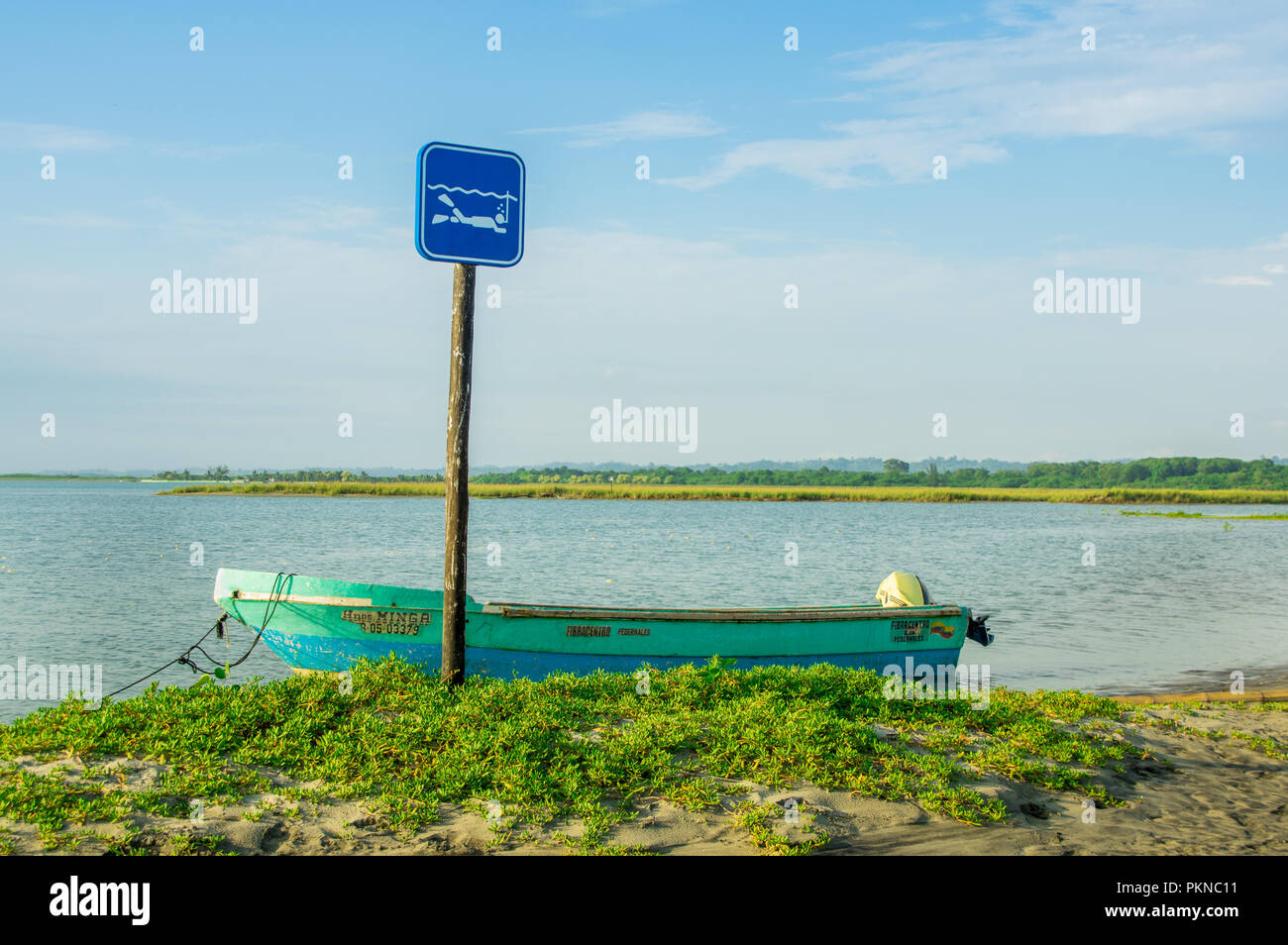 MANABI, ECUADOR, MAY, 29, 2018 Outdoor view of fishing boat in the shore and informative sign of snorkeling area allow, during a gorgeous sunny day in the beach of Cojimies Stock Photo