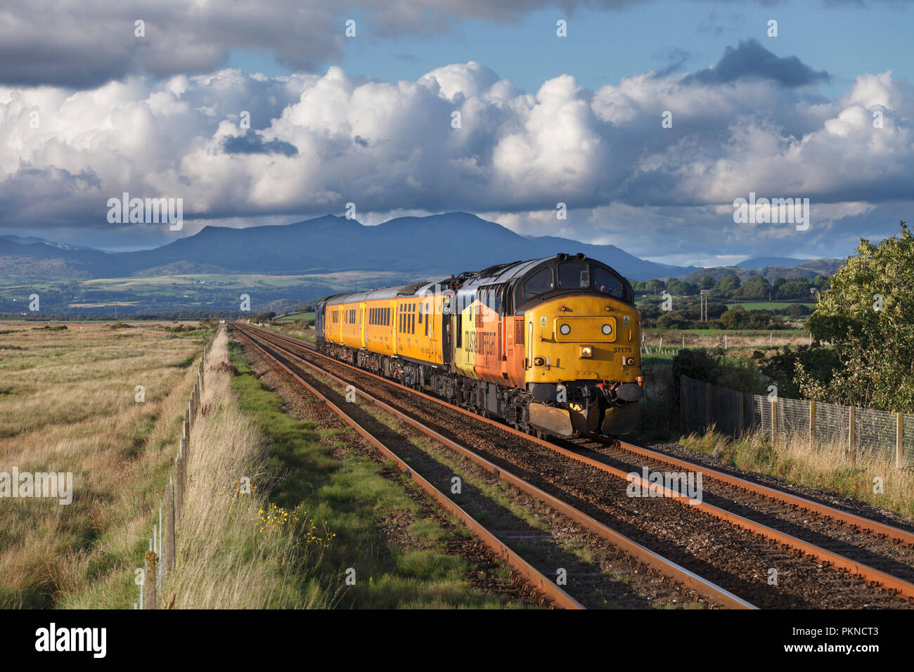 A Colas Railfreight class 37 locomotive passing Dunnerholme on the Cumbrian coast line with a Network rail infrastructure monitoring train (PLPR) Stock Photo