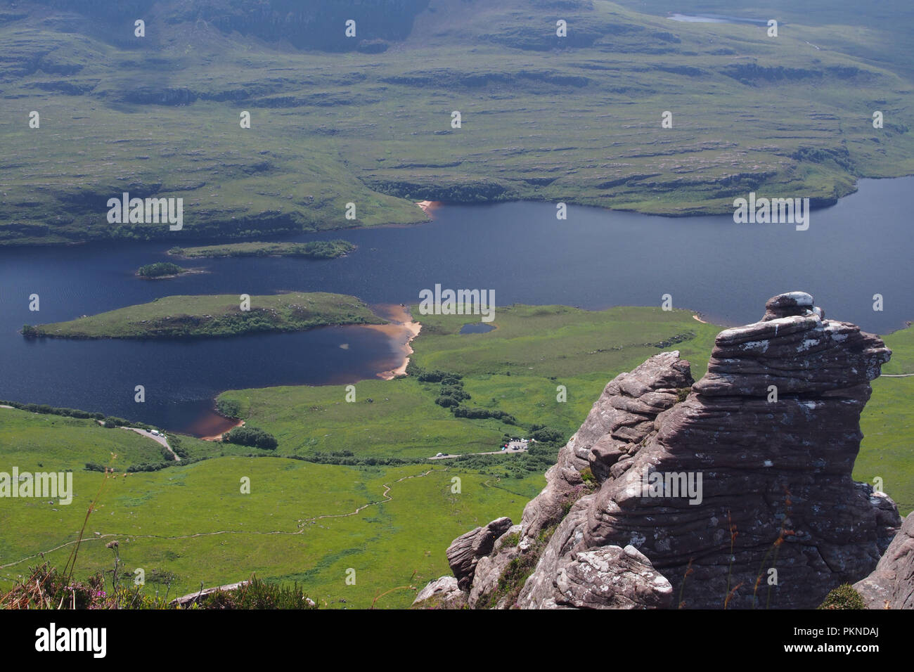 A view down from Stac Pollaidh on the Coigach Peninsula to Loch Lurgainn and to the surrounding countryside and mountainsroad Stock Photo