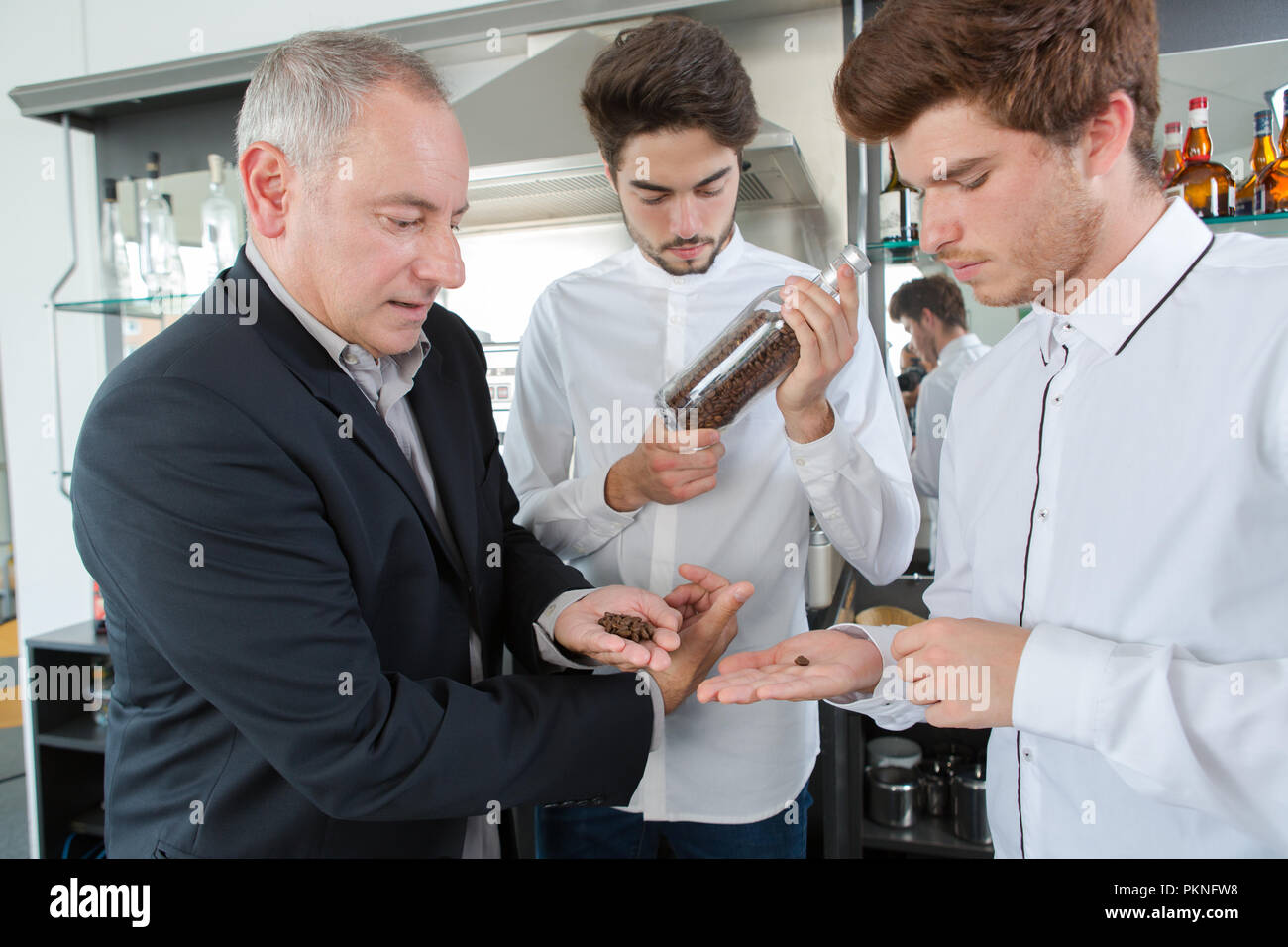 boy apprentices smeling aroma arabica coffee beans Stock Photo - Alamy