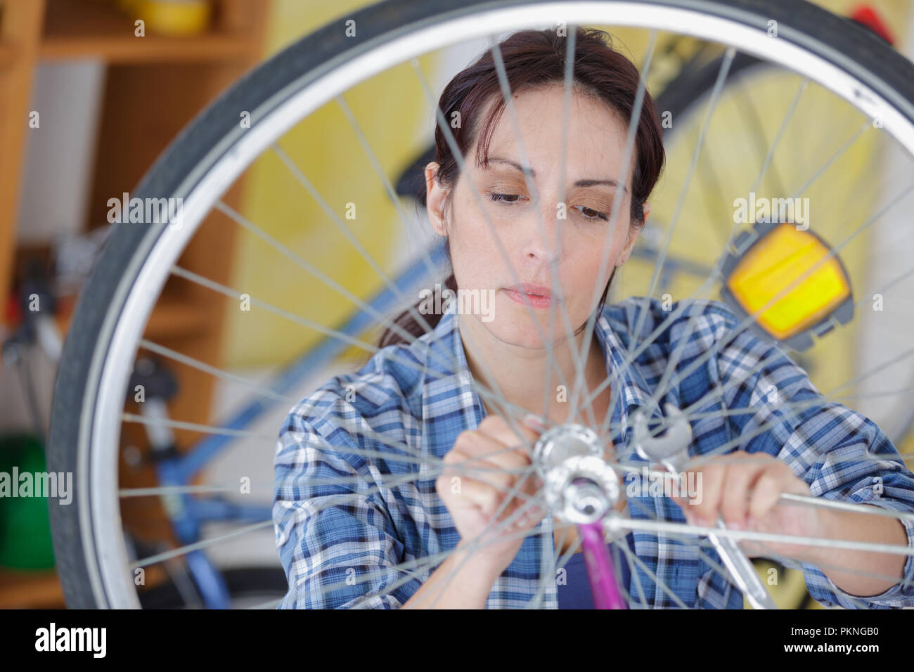 young woman repairing bicycle wheel Stock Photo - Alamy