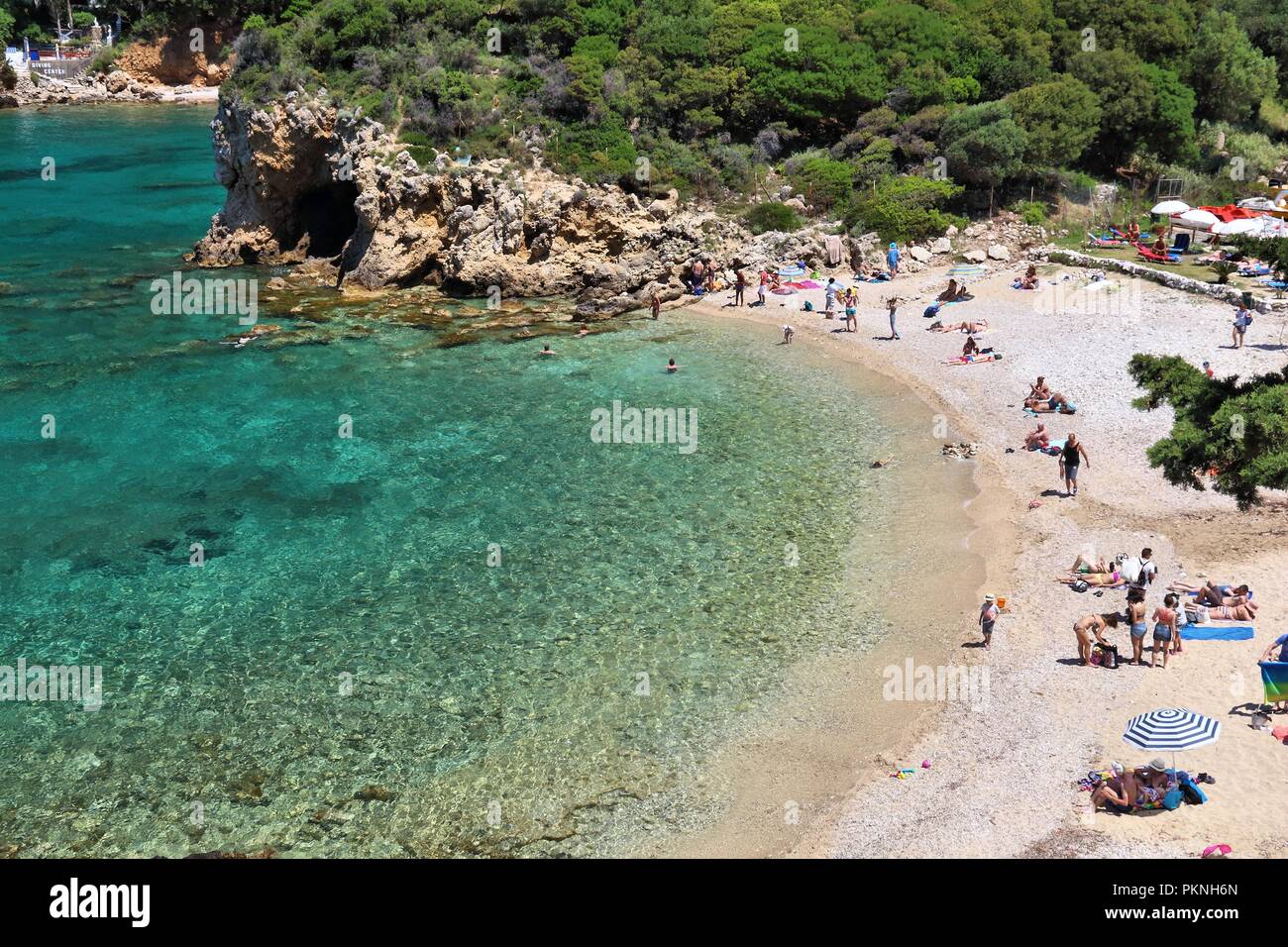 CORFU, GREECE - JUNE 2, 2016: People enjoy the beach in Paleokastritsa, Corfu Island, Greece. 558,000 tourists visited Corfu in 2012. Stock Photo