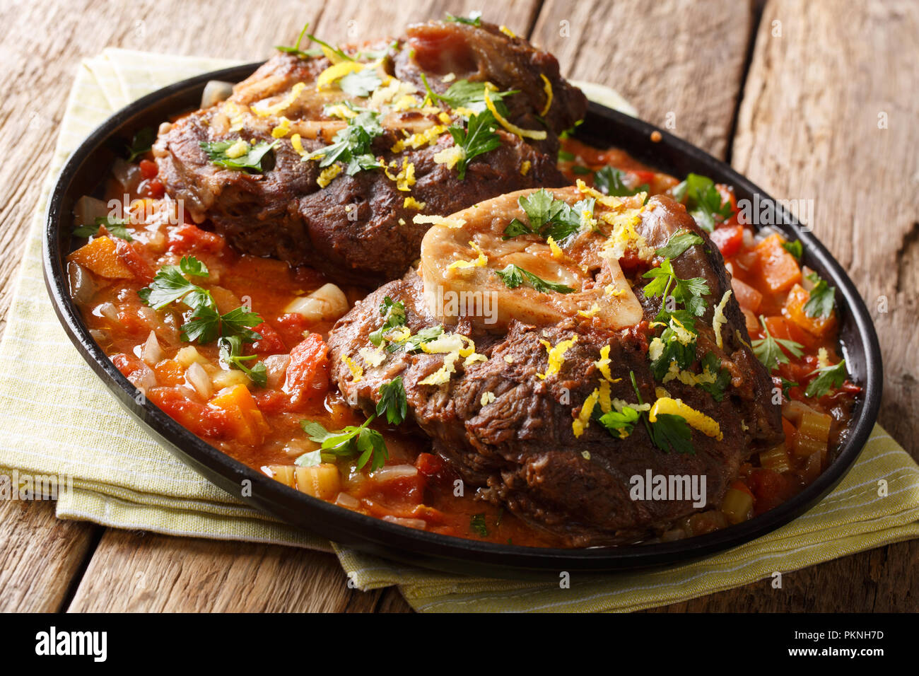 beef shank Ossobuco alla Milanese with gremolata and spicy sauce closeup on the table