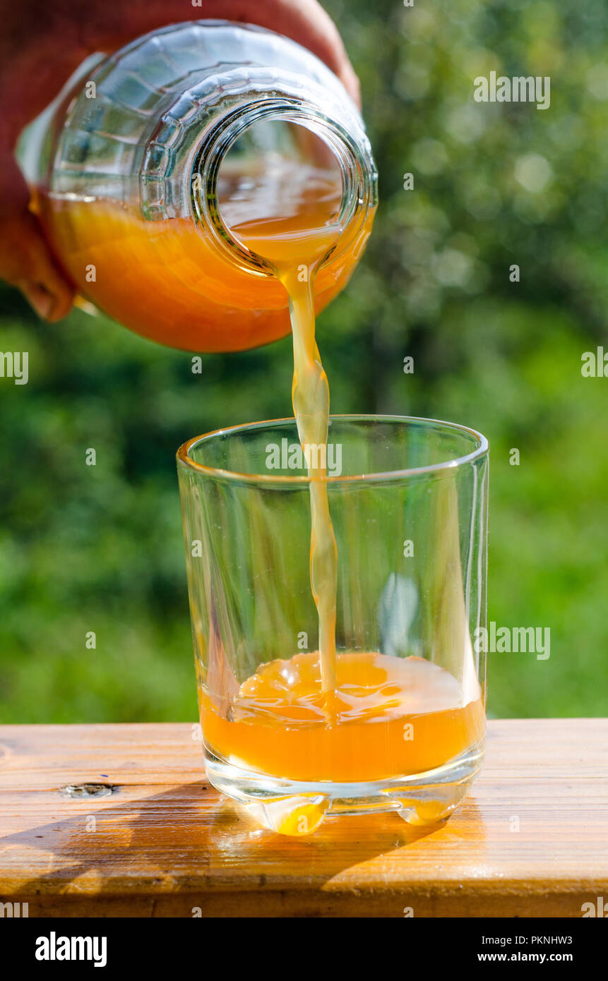 pouring fresh raw unfiltered apple juice into a glass Stock Photo Alamy