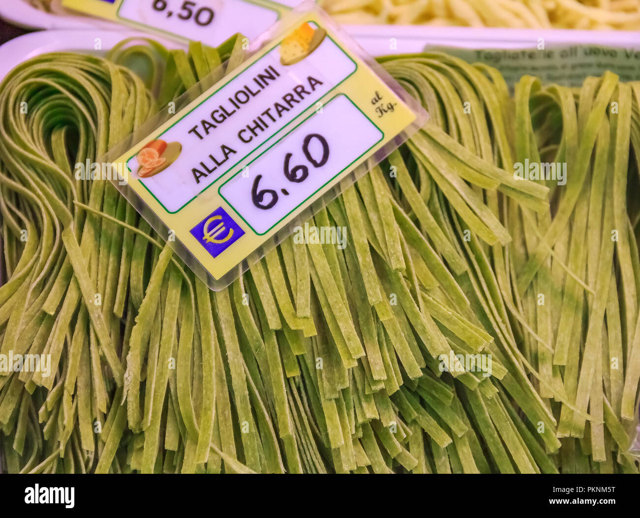 https://c8.alamy.com/comp/PKNM5T/fresh-homemade-tagliolini-made-with-a-chitarra-pasta-cutter-at-a-market-in-ventimiglia-italy-with-a-price-tag-PKNM5T.jpg