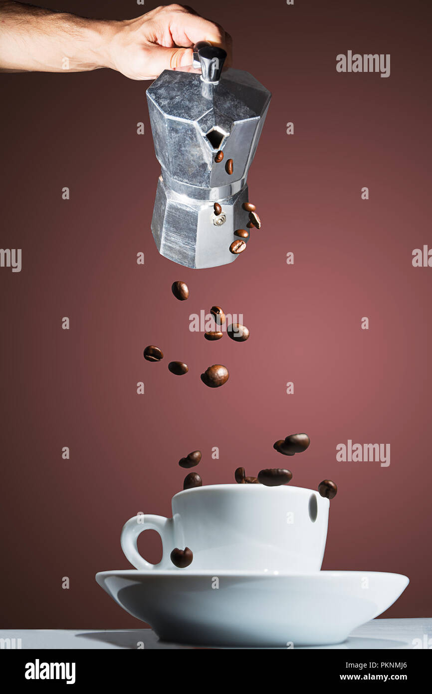 Coffee pot pouring roasted coffee beans into the cup Stock Photo Alamy