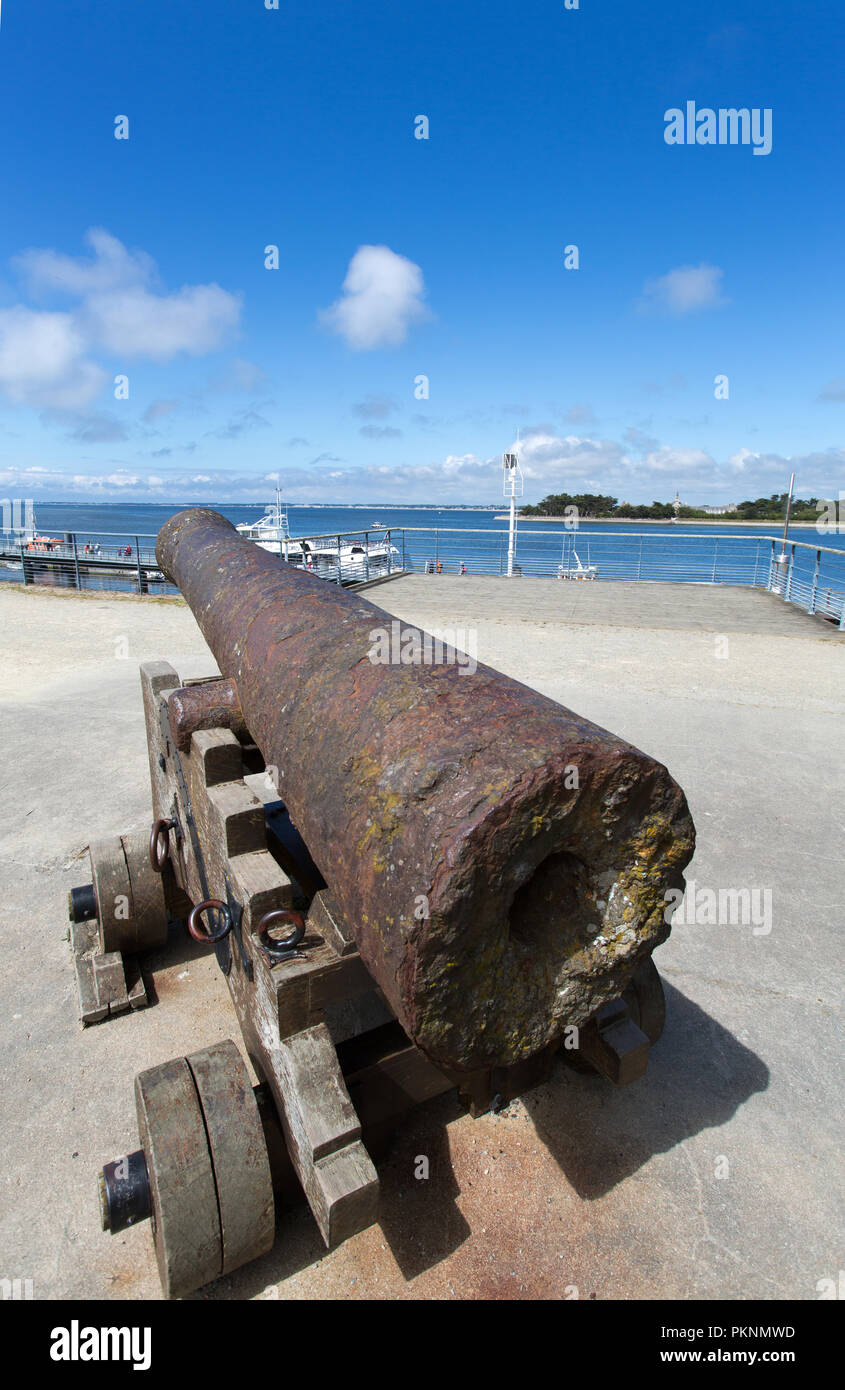 Le Croisic, France. Picturesque view of a rusty antique cannon with Le Croisic promenade, adjacent to Rue du Mail de Broc, in the background. Stock Photo