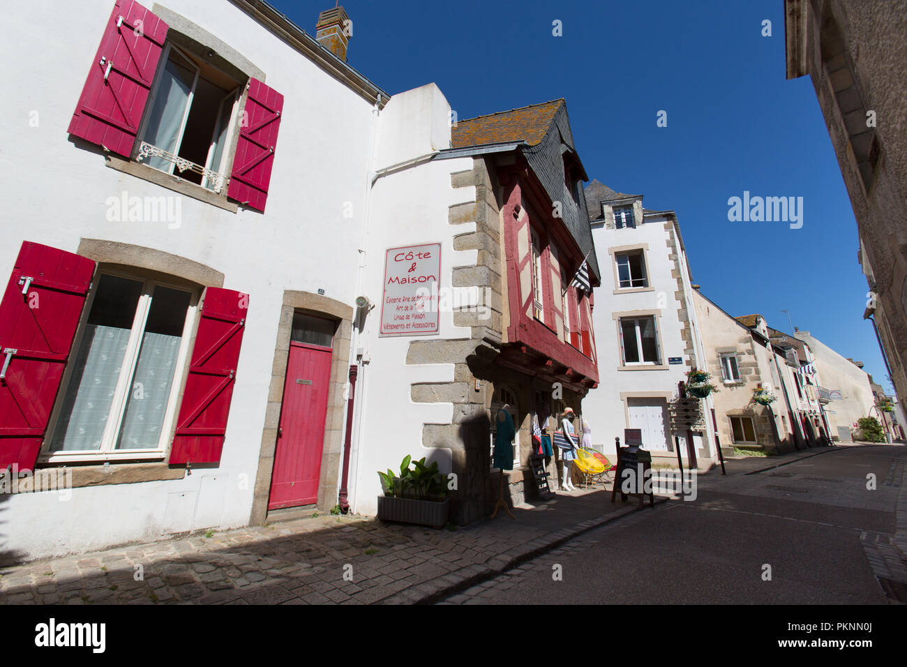 Le Croisic, France. Picturesque view of residential dwellings and a clothing (vetements) shop at Le Croisic’s Rue de l'Église. Stock Photo